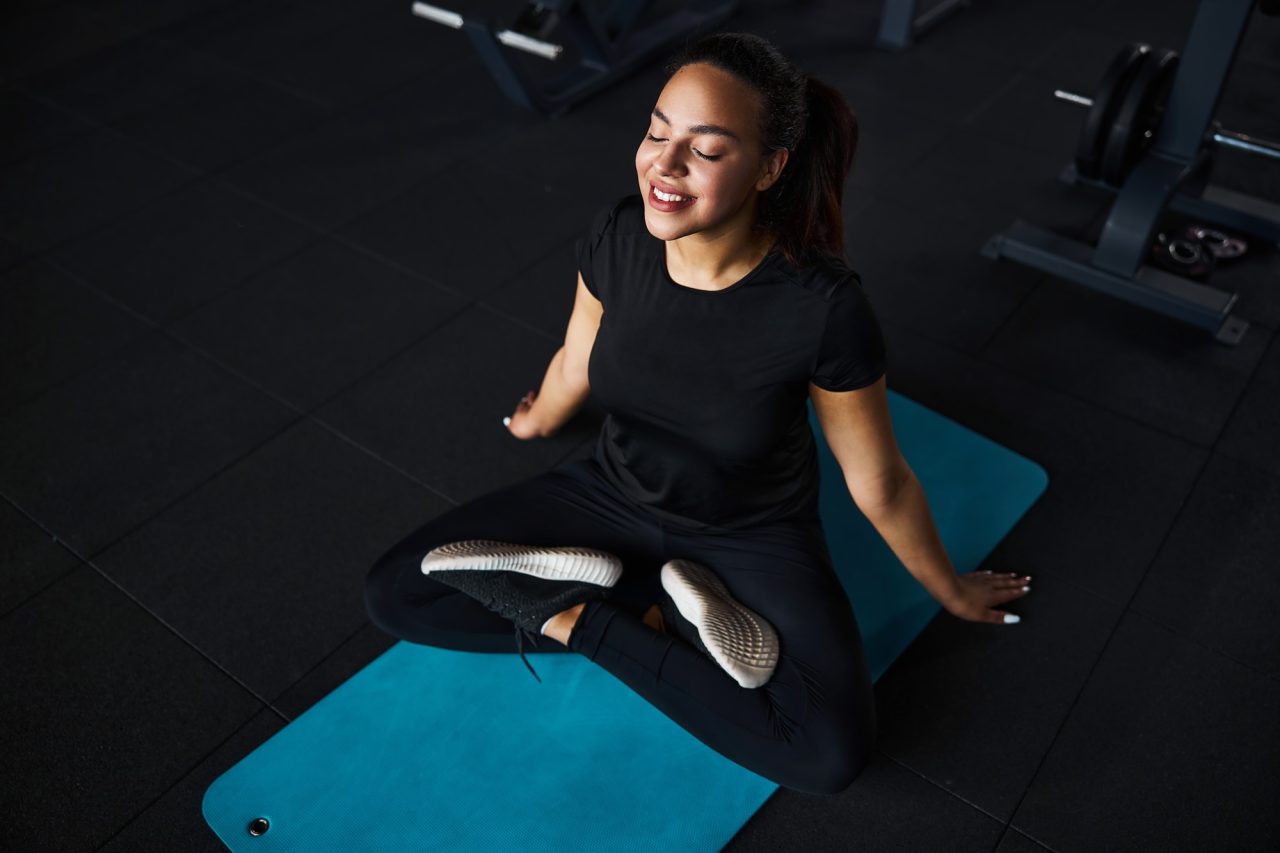 mindful-young-woman-doing-yoga-in-gym.jpg